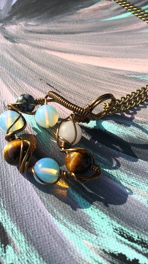 Orbital Thoughts. Opalite, rose quartz, snowflake jasper and tigers eye necklace. Made by Eyesthatburnthemind.